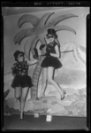 THO-1161 Twee leden van carnavalsvereniging Limburgia poseren bij een decor met palmbomen in zaal Odeon aan de ...