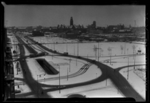 THO-1171 Overzicht vanaf het Groothandelsgebouw over een besneeuwde stad. Het stationsplein met links de Weenatunnel, ...