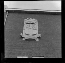 THO-13 Gevelsteen met het wapen van de stad Rotterdam en de tekst 'Sterker door strijd'. De steen hangt aan de zijgevel ...