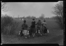 THO-1334 Vier scholieren met fiets kijken naar het paasvoetbaltoernooi op het sportterrein van Laag Zestienhoven.