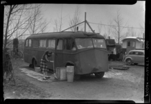 THO-145 Met een bezem veegt een vrouw een stoep schoon bij een woonwagen op woonwagenkamp aan de Oude Kleiweg bij ...