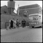 THO-1528 Reizigers wachten bij een bushalte van de streekbus naar Rotterdam in Oud IJsselmonde. Links staat een ...