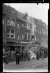 THO-1537 Een man gooit smeulende resten naar beneden na een brand in woningen aan de Beijerlandselaan. Twee zolders ...