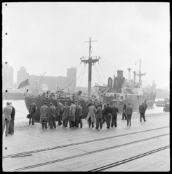 THO-1732 Een groep mensen wacht op een schip aan de Rijnhaven N.z.. Op de achtergrond de Coöp op Katendrecht.