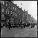 THO-1856 Leden van een muziekkorps lopen over de Schiedamseweg. In het midden de Watergeusstraat.