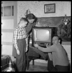THO-1867 Een gezin uit de Jasmijnstraat staat in de huiskamer bij een Philips-televisie. Het gezin heeft de televisie ...
