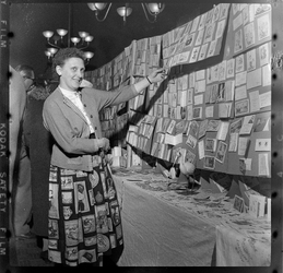 THO-1968 Tijdens een beurs voor verzamelaars in gebouw 'De Twaalf Provinciën' staat een vrouw bij een stand met kaarten.