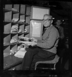 THO-2026 Postbesteller F. Bontekoe sorteert post tijdens de kerstdagen. Hij werkt op het Spoorwegpostkantoor, is ...