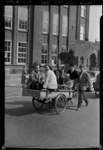 THO-2064 Jongeren (mogelijk leerlingen) fietsen met een bakfiets bij de Hogere Burger School (HBS) op de Bergselaan.