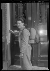 THO-267 Een jonge toerist trekt aan de bel bij de Jeugdherberg Kralingen aan de Lambertusstraat 104. Op de deur hangt ...