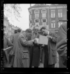 THO-3042 Bezoekers van een postzegelmarkt aan het Noordplein bekijken een album met postzegels. Op de achtergrond links ...