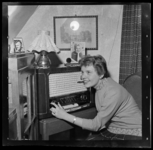 THO-3167-1 Portret van zangeres Greetje Kauffeld bij een radio in haar woning aan de Brielselaan. Kauffeld is de nieuwe ...