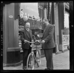 THO-3171 H.W.P. Willemsen (links) en A.F. van Zessen staan met een fiets voor fietswinkel A.F. van Zessen aan de Claes ...