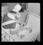 THO-427 Een verpleegster voedt een baby in het Sophia Kinderziekenhuis aan de Gordelweg.