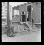 THO-432 Sluiswachter van de Leuvesluis voert duiven op het Plein 1940 bij de Blaak. Op de achtergrond het gebouw van ...