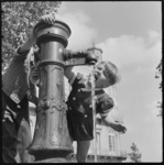 THO-495 Kinderen drinken water bij een drinkfontein op de Veerkade.