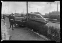 THO-56 Een politieagent staat bij een auto die op de Schiedamseweg door gladheid tegen een lantarenpaal is gereden. Ter ...