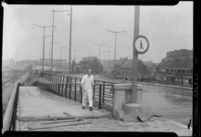 THO-621 Een man in witte overall loopt over het Rozenviaduct over de Rozenlaan. Op de achtergrond links de achtergevels ...