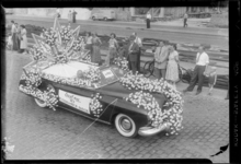 THO-674 Tijdens het bloemencorso rijdt de met anjers versierde auto van het Rotterdamsch Parool over de Mariniersweg. ...