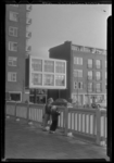 THO-914 Twee kinderen staan op de Karnemelksebrug over het Stokviswater bij de Goudsesingel. Op de achtergrond de ...