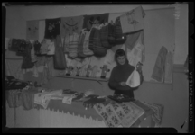 THO-956-1 Een vrouw staat bij een kraam met textiel en knuffelberen op de jeugdmarkt van de commissie 'Jeugdrecreatie' ...