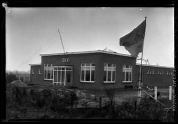THO-968-1 Een vlag wappert bij het nieuwe clubgebouw van voetbalvereniging C.V.V. aan de Dorpsweg.