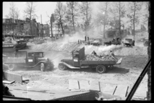 1980-5116-1 Puinruimers zijn bezig met het dempen van de Blaak met puin. Op de voorgrond staat een vrachtwagen vol ...