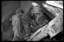 1980-5128 Soldaten bewerken met een drilboor grote brokstukken gewapend beton in het door het bombardement van 14 mei ...