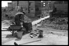 1980-5147 Op het dak van een pand aan de Wijnstraat is een man bezig met het opbouwen van een schoorsteen op het dak ...