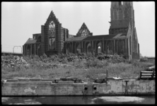 1980-5239 De ruïne van de Laurenskerk gezien vanaf de Meent. Op de voorgrond liggen nog bergen puin begroeid met gras ...