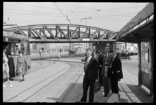 1980-5343 Mensen staan te wachten bij de tramhalte op het Hofplein. Links stappen mensen uit een tram. Op de ...