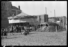 1980-5369 Kinderen spelen in het zand voor een draaimolen in de buurt van de Binnenweg. Naast de draaimolen staat een ...