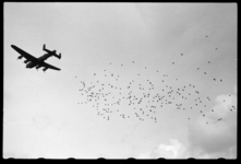 1980-5535 Operatie Manna. Een geallieerd vliegtuig lost voedselpakketten boven de weilanden bij Terbregge ten behoeve ...