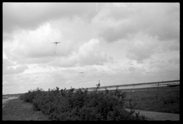 1980-5537 Operatie Manna. Een geallieerd vliegtuig lost voedselpakketten boven de weilanden bij Terbregge ten behoeve ...