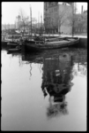 1980-5775 Binnenvaartschepen in de Oudehaven. Op de achtergrond is de Geldersekade te zien. Het Witte Huis spiegelt in ...