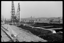 1980-5813 Reparatie van kademuren langs de Boompjes. Overzicht van het bouwterrein. Links heimachines, rechts de oude ...