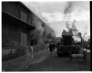 1048-06 Brandweerwagen en brandweermannen bij een brand bij N.V. Katoenveem aan de Keilestraat.