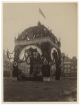XXXIII-98-2 Versiering van de Nieuwe Markt rondom een standbeeld met bovenop de Nederlandse vlag, ter gelegenheid van ...