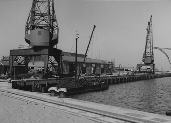 1968-1473 Herstelwerkzaamheden van de kademuren in de Merwehaven met hijskranen.