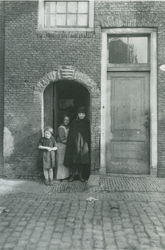 1968-691 Een gevelsteen boven poortje: drie liggende haringen met daarboven een kroon, naast woonhuis nummer 38, Voorhaven.