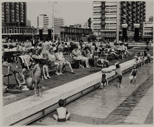 1969-2765 Spelende kinderen in het waterbassin op het Schouwburgplein, op de achtergrond (links) het Hilton Hotel en ...
