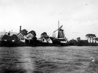 1975-183 De Schaardijk (Kralingseveer) met rechts oliemolen de Liefde, gezien vanaf de Nieuwe Maas.