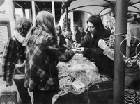 1975-737,-738 Sieradenkraampje met als dak de luifels van deC '70-manifestatie op het Beursplein.Op de achtergrond de ...
