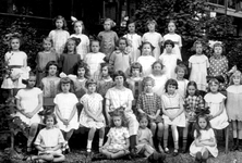 1989-3200 Groepsfoto van meisjes met schooljuffrouw in de tuin van de school voor gewoon lager onderwijs aan de ...