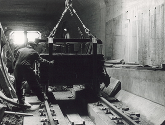 X-11-523 Aanleg van de metrotunnel onder de Nieuwe Maas.Oude rails, samen met zand, voor het ballasten van de tunnel ...