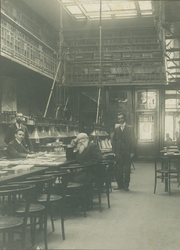 XXI-86 Leeszaal van de Gemeentebibliotheek aan de Boijmansstraat met de ambtenaren: zittend links F.J. Hoogeveen, ...