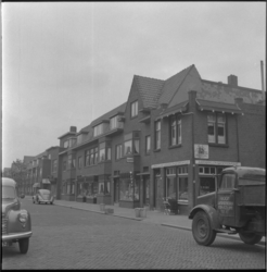 11151 De Prins Hendrikstraat met woningen, winkels en verkeer. Rechts de Schoolstraat. Opname richting het oosten.