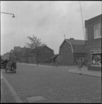 11154 De Prins Hendrikstraat met woningen, winkels en verkeer. Rechts de Blesstraat. Opname richting het oosten.