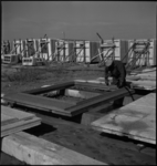 1433 Een bouwvakker aan het werk bij een voorgeproduceerd, betonnen gevelelement voor de systeembouw van woningen aan ...
