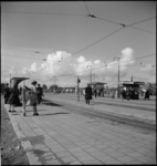 1469 Wachtende reizigers bij tramhaltes aan het Weena. Op de achtergrond het Stationsplein.